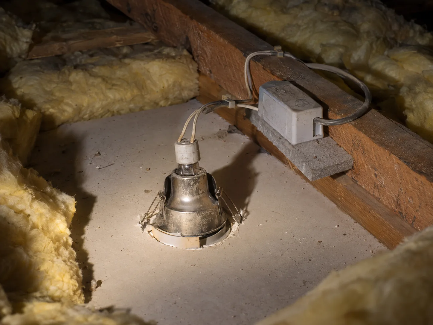 An old 12 volt halogen can and its transformer in the roof space, insulation cut back around them